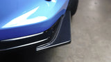 Close-up of a blue car's front bumper with carbon fiber texture.