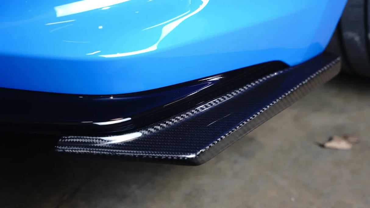 Close-up of a car's carbon fiber bumper on a blue vehicle