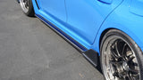 Close-up of a blue car's side with a black rim on a gray pavement.